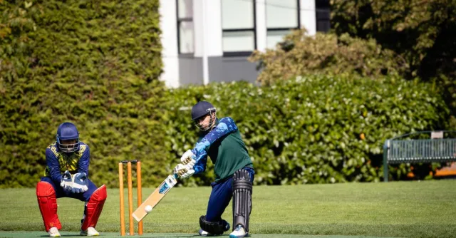 Dynamic cricket match scene with batsman in action, set outdoors in Victoria, Canada.