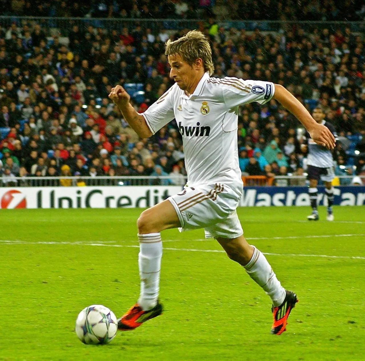 A wide view of a modern professional soccer stadium during an evening match.