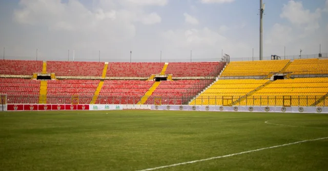 A sunny view of the empty seats and lush grass at Baba Yara Sports Stadium in Kumasi, Ghana.