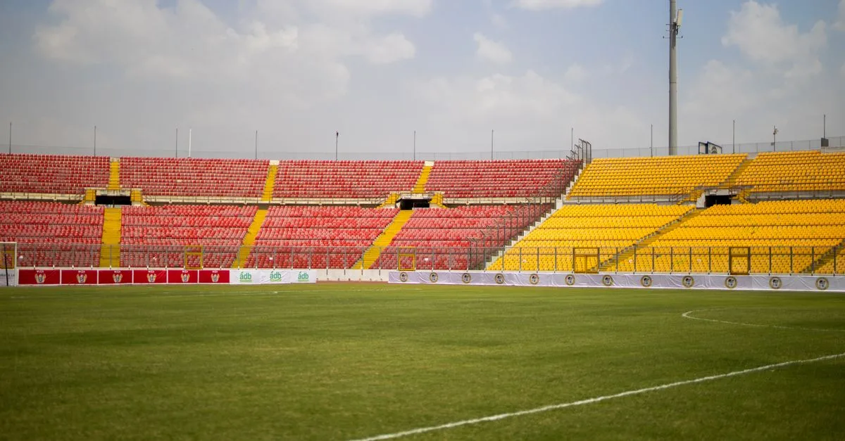 A sunny view of the empty seats and lush grass at Baba Yara Sports Stadium in Kumasi, Ghana.