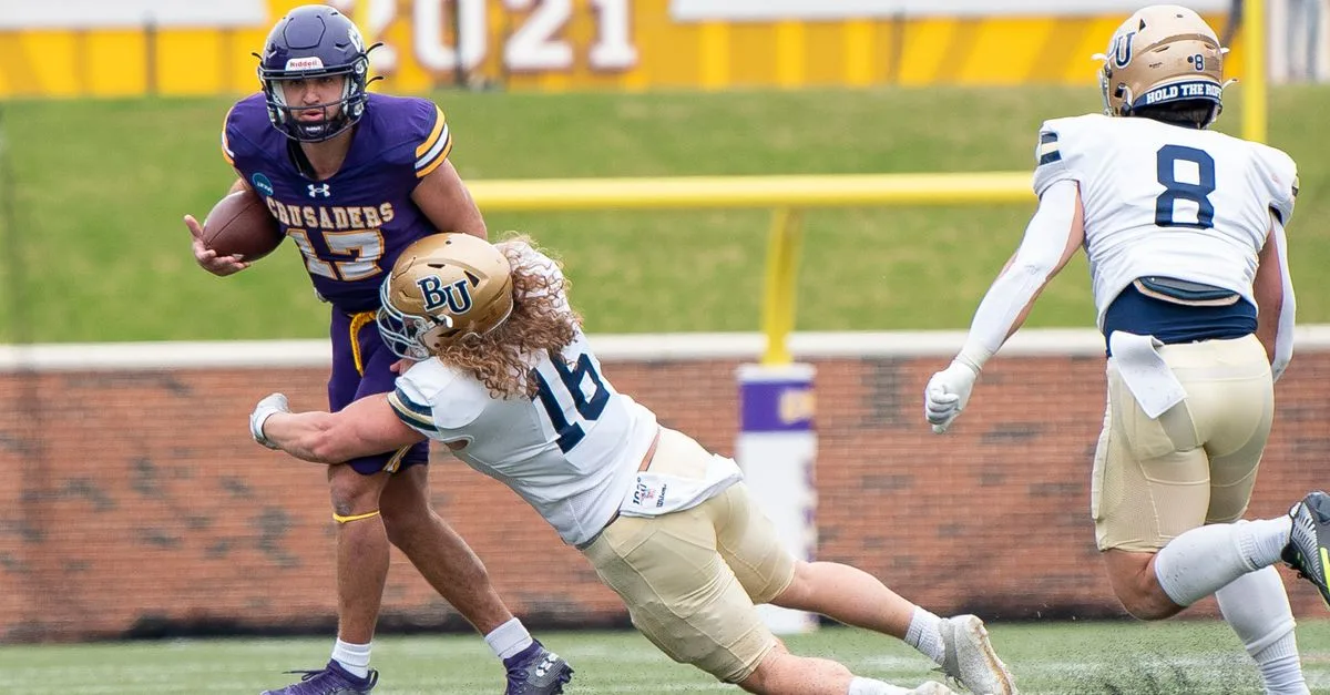 Action shot of a college football game with players in motion on the field.