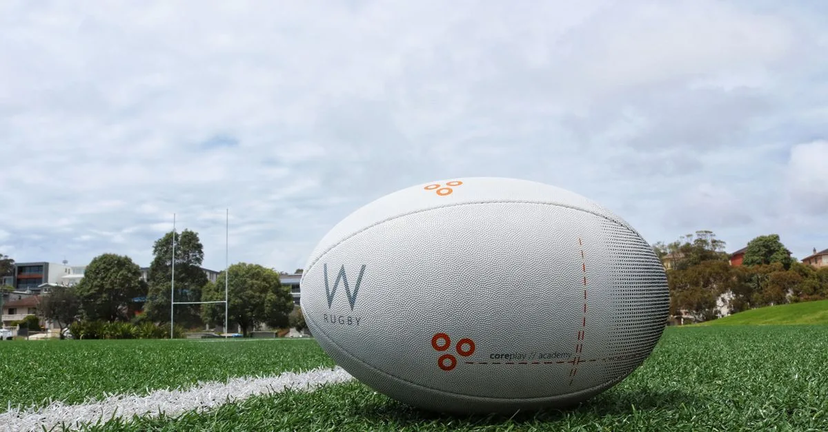 A detailed shot of a rugby ball on a green sports field, perfect for sports equipment themes.