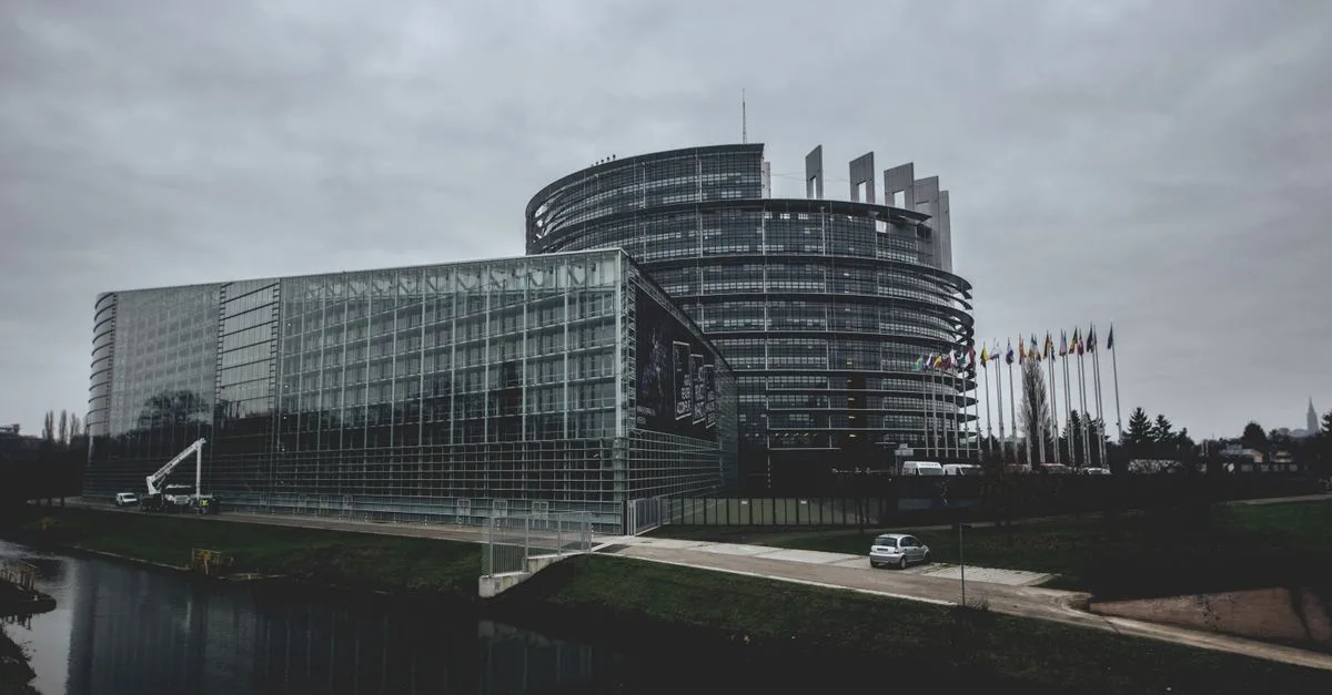 Modern architecture of the European Parliament in Strasbourg on a cloudy day.