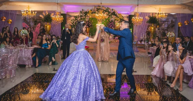 Father and daughter waltzing at an elegant quinceañera celebration.