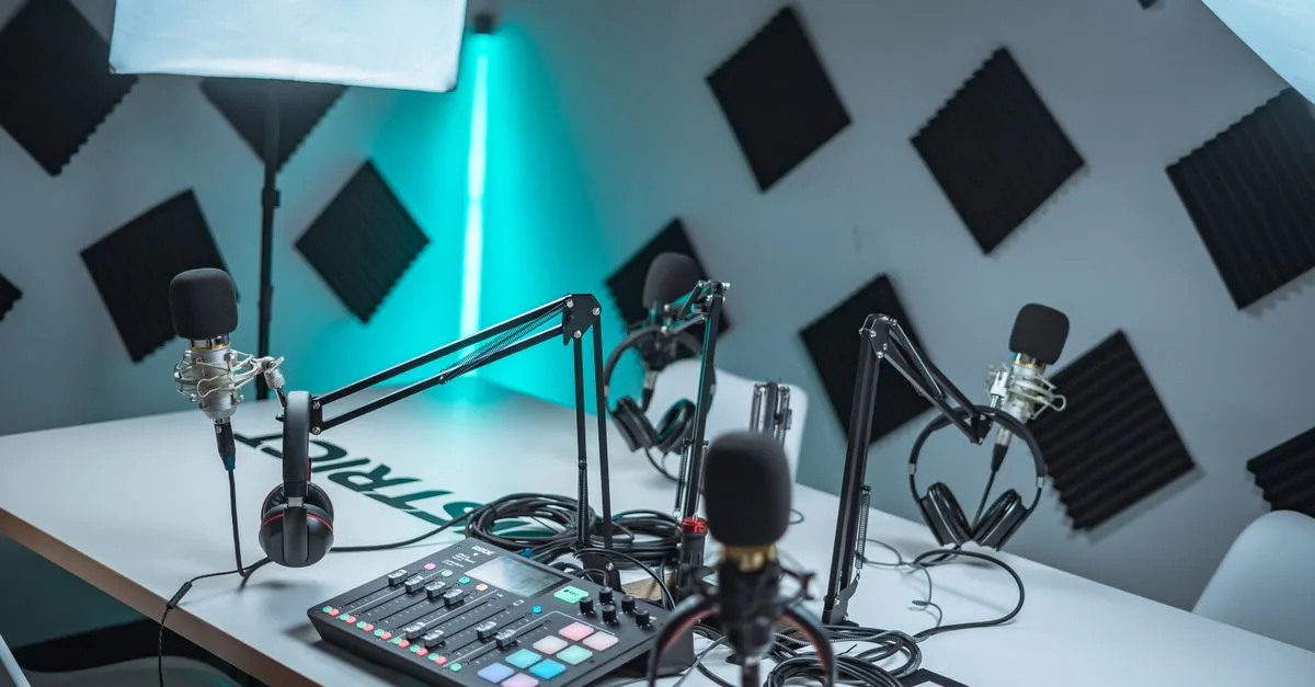 Sleek podcast studio setup featuring microphones, audio mixer, and acoustic panels.