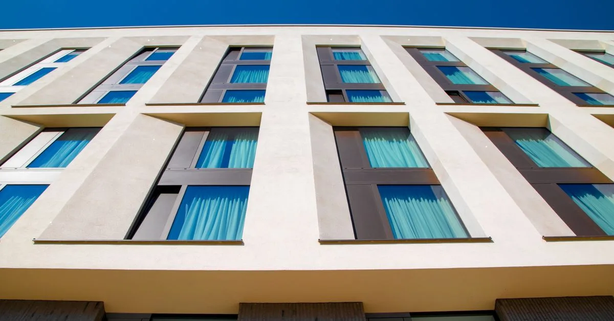 Low-angle view of a modern building facade in Hamburg with clear blue sky.