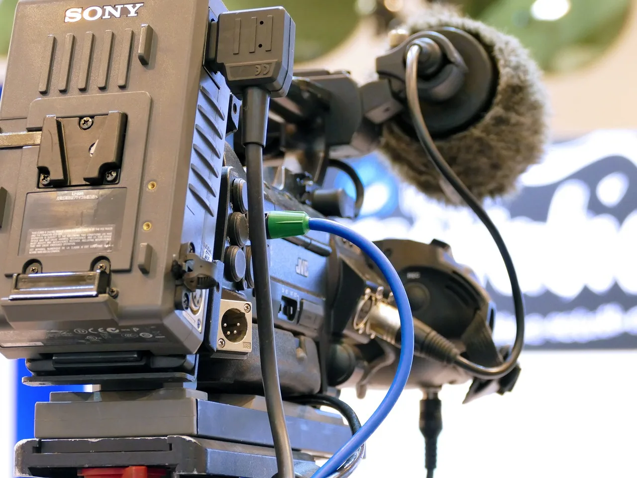 A professional studio microphone in a dimly lit broadcast setting.