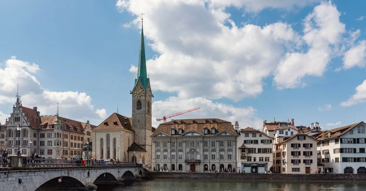 Panoramic view of Fraumünster Church and historic buildings along the water in Zurich, Switzerland.