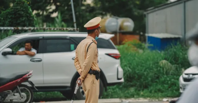 Traffic officer managing road with vehicles in an urban outdoor setting.