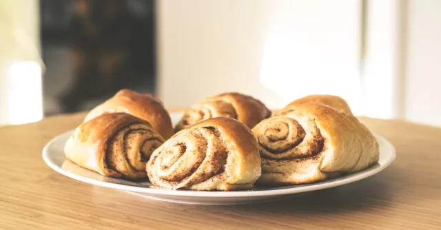 Warm and inviting cinnamon rolls on a white plate, perfect for a sweet treat.