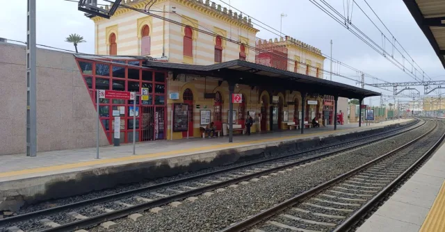 Charming Dos Hermanas train station in Andalucía, Spain, showcasing classic architecture and busy platforms.