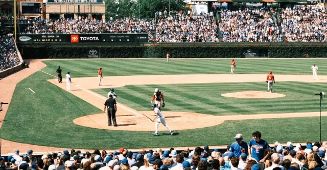 Vibrant scene of a baseball game at Wrigley Field with packed grandstands and players in action.