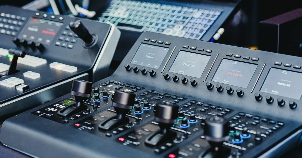 Close-up of a high-tech video editing console with control knobs and screens.