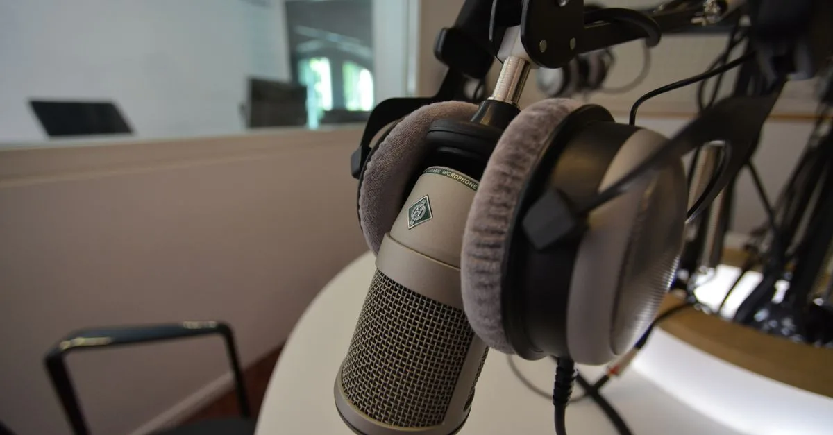 Close-up of a studio microphone with headphones in a recording setting, emphasizing audio quality.