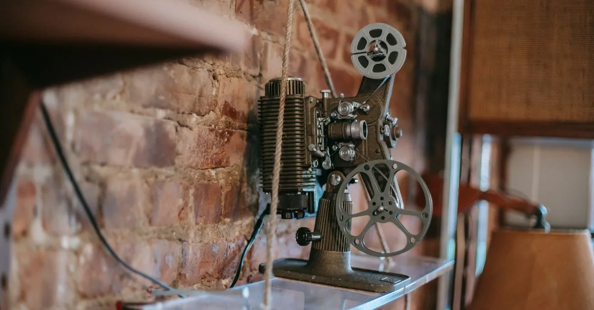 Retro film projector placed on glass shelf near brick wall in cozy apartment