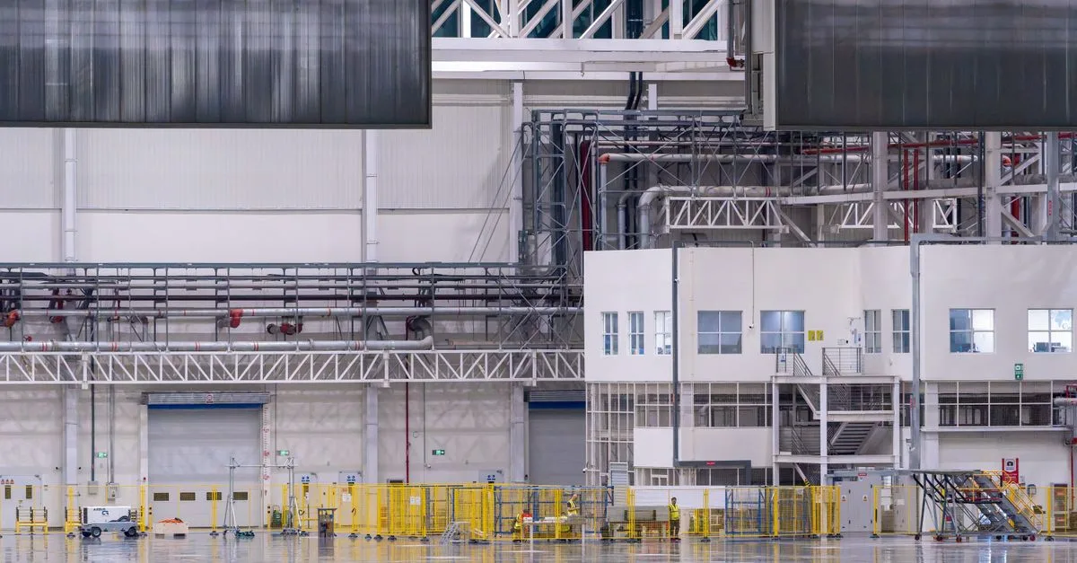 Spacious modern factory interior showcasing industrial manufacturing machinery.