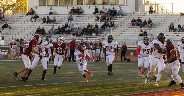 Intense American football game with players in action at a bustling stadium, showcasing team sportsmanship.