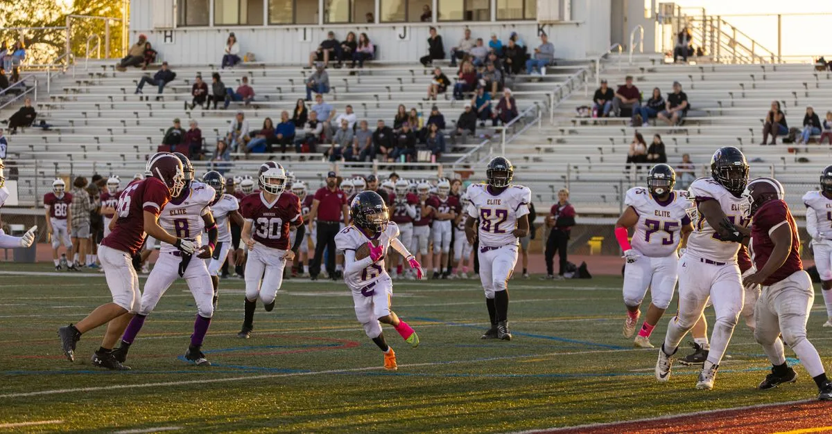 Intense American football game with players in action at a bustling stadium, showcasing team sportsmanship.