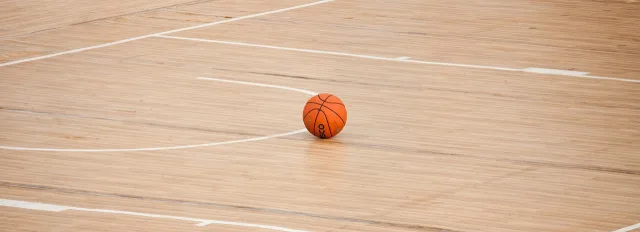 An empty basketball court inside a large arena.