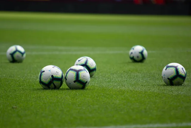 A professional soccer pitch inside a large stadium under bright floodlights.