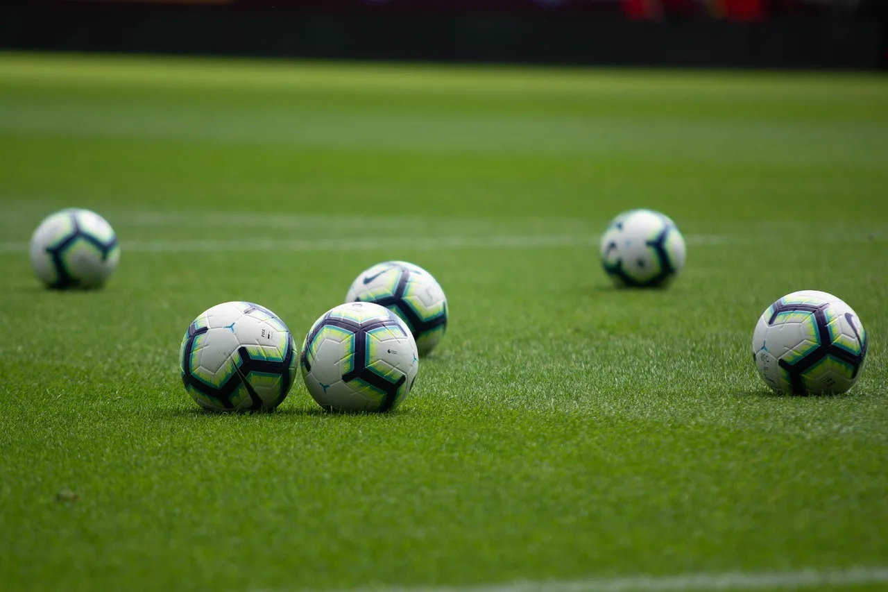 A professional soccer pitch inside a large stadium under bright floodlights.