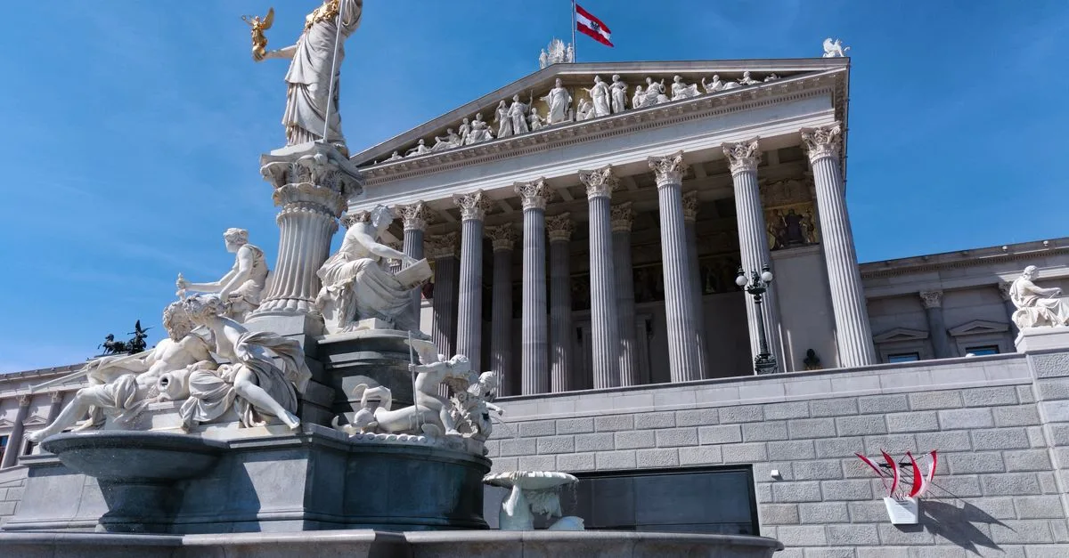The majestic Athena Fountain outside the historic Vienna Parliament Building on a sunny day.