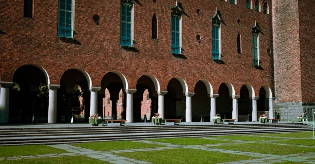 A view of the iconic Stockholm City Hall featuring a brick facade with arches and columns.