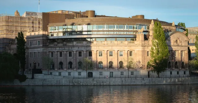 View of the Riksdag Building in Stockholm, capturing its architectural beauty by the river.