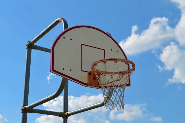 An empty professional basketball court under bright arena lights.