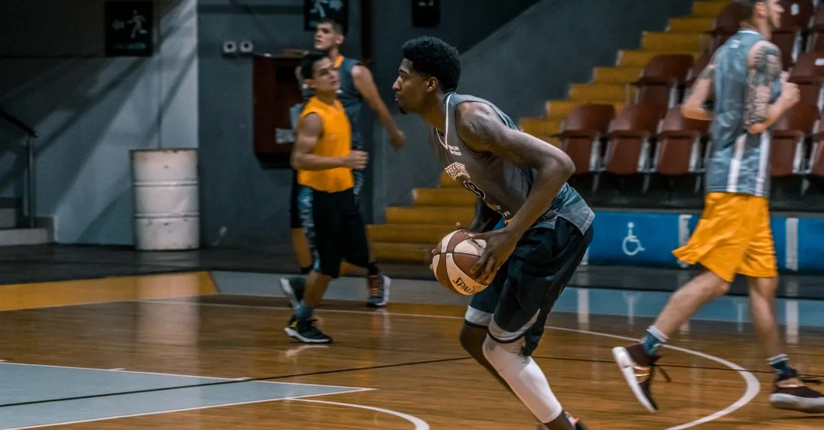 Young athletes engage in a dynamic basketball practice indoors, focused on skill development.