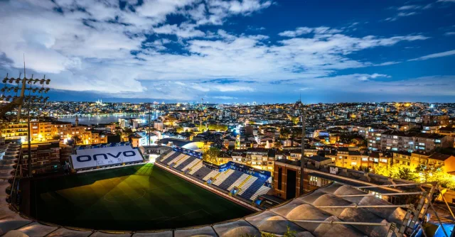 Captivating aerial view of Istanbul city and a stadium illuminated at night under a starry sky.
