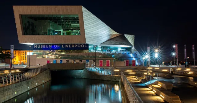 Illuminated Museum of Liverpool building at night, showcasing modern architecture.