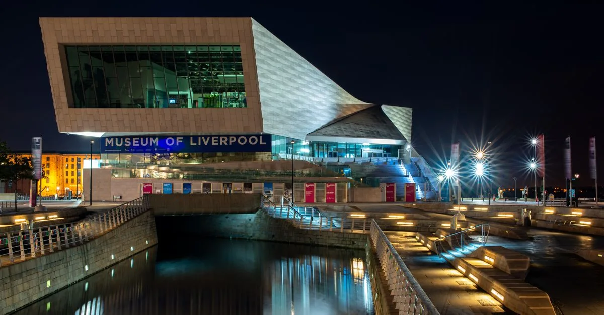 Illuminated Museum of Liverpool building at night, showcasing modern architecture.