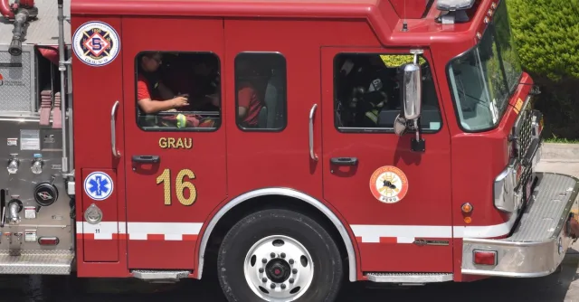 Close-up of a red firetruck in Lima, Peru, showcasing vehicle details and firefighters inside.