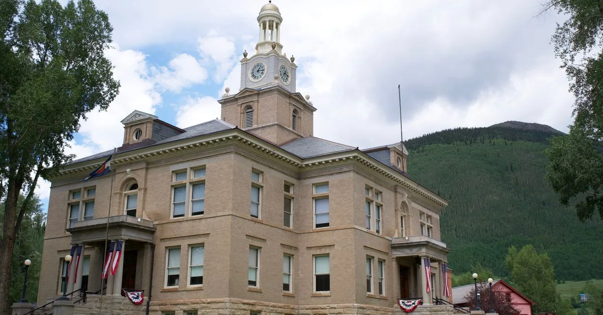 The classic architecture of San Juan County Courthouse in Silverton, Colorado, nestled in a mountain town setting.