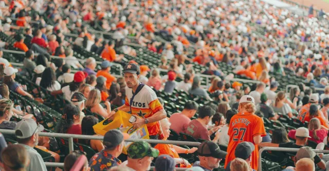 Packed Houston stadium featuring enthusiastic baseball fans during a major league game.