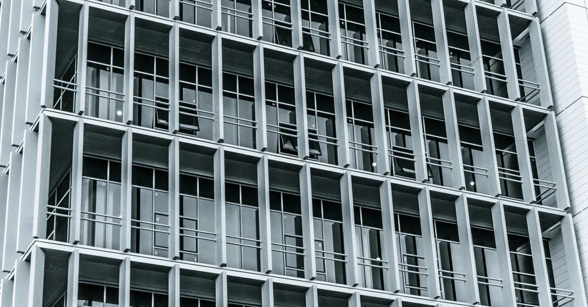 Close-up of a modern highrise building facade showcasing a grid pattern of windows and balconies.