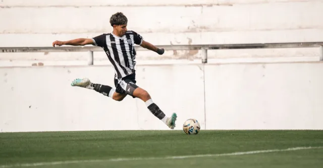 Dynamic shot of a soccer player in mid-air kick on green field.