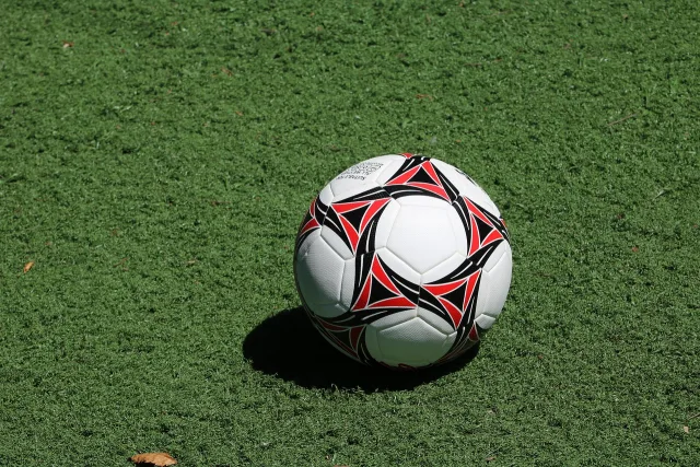 A wide view of a professional soccer stadium pitch during the day.