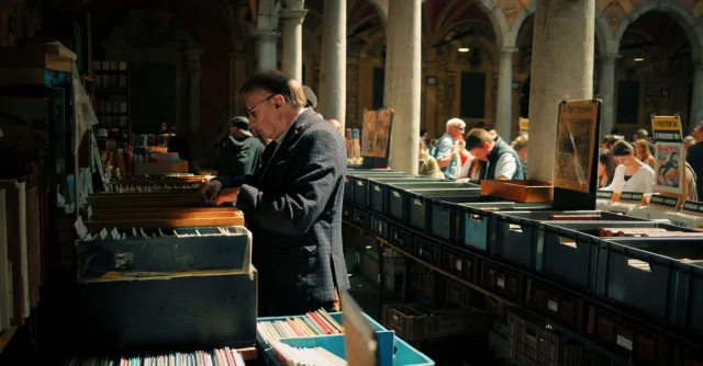 A bustling vintage market in Lille, France with people browsing through records and books.