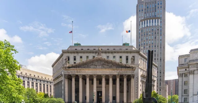 View of the historic New York County Courthouse with clear skies and cityscape.