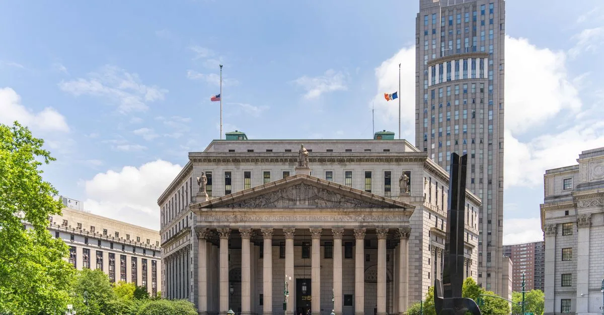 View of the historic New York County Courthouse with clear skies and cityscape.