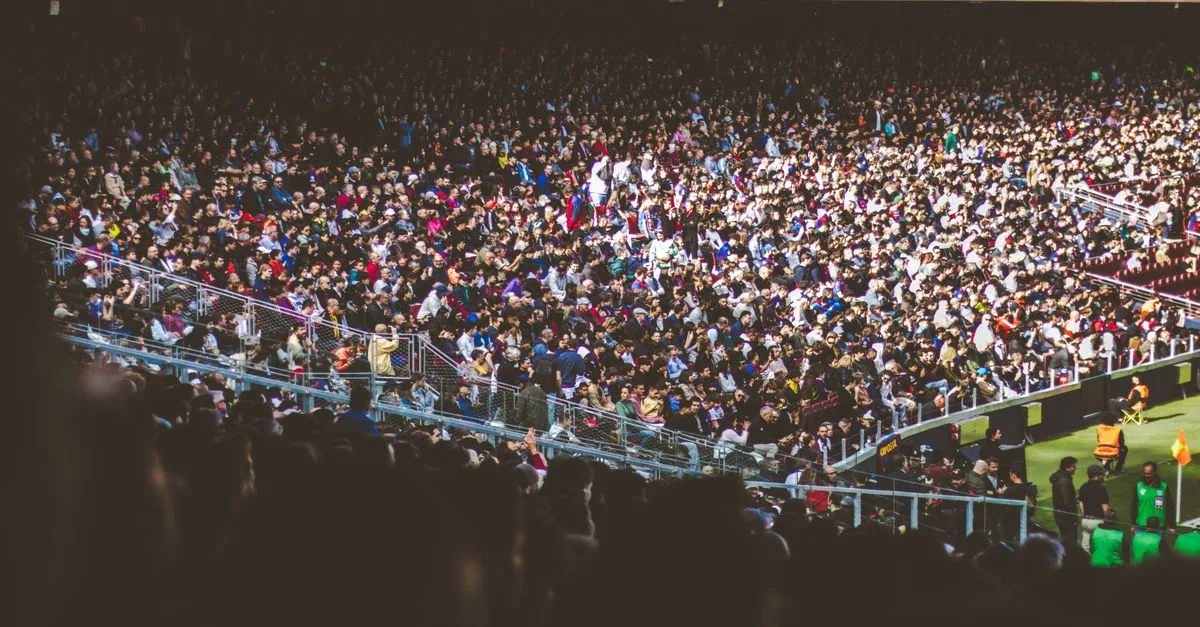 A vibrant crowd fills a football stadium during a lively match.
