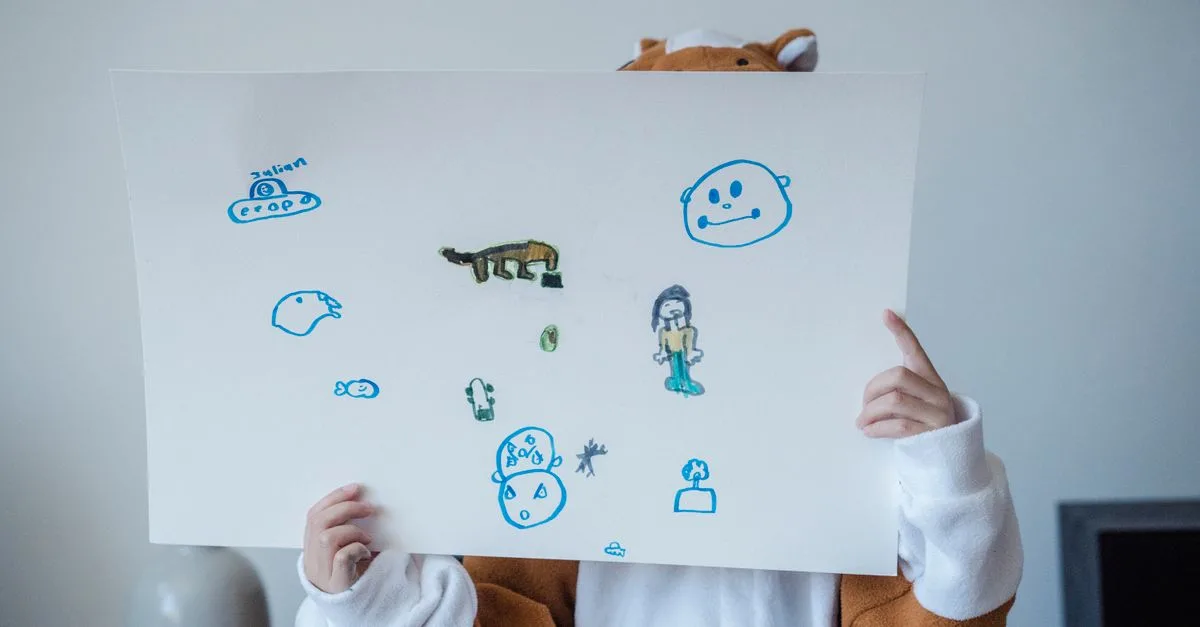 A child in a costume holds a playful drawing with colorful sketches, expressing creativity.