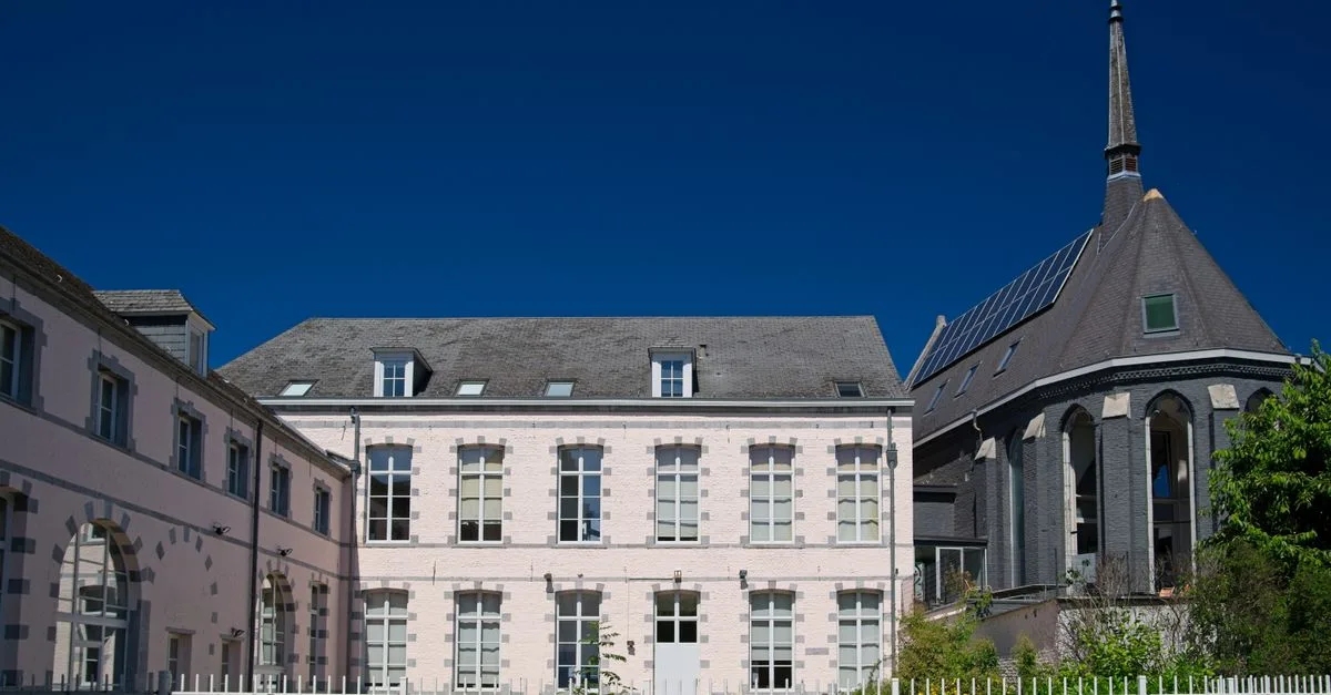 A historic French building with traditional architecture under a bright summer sky.