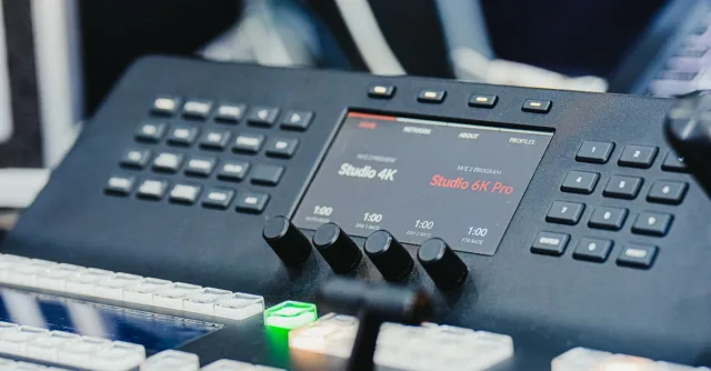Closeup of a high-tech audio video control panel featuring digital displays and control buttons.