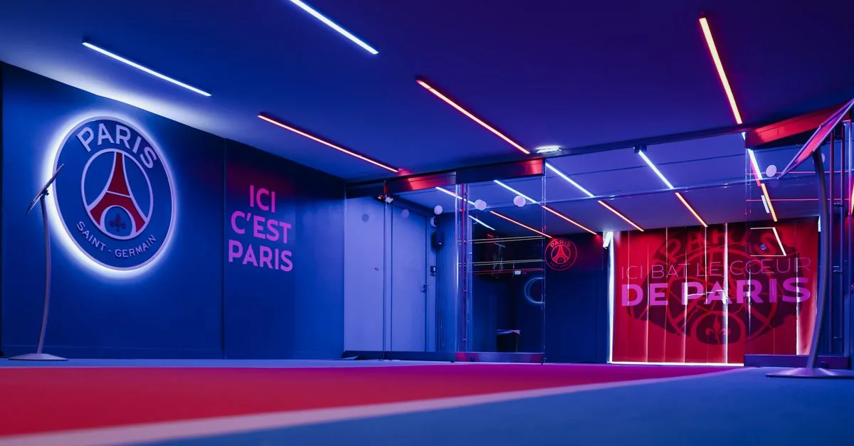 Spacious PSG entrance hallway in Paris with striking neon lighting and club branding.