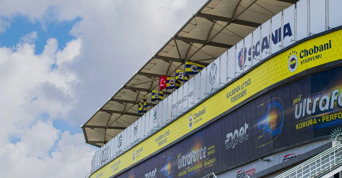 A stadium facade featuring Chobani and sports brand ads with a Turkish flag.