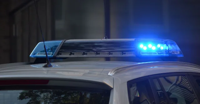 Close-up of a police car's flashing blue lights in an urban environment.