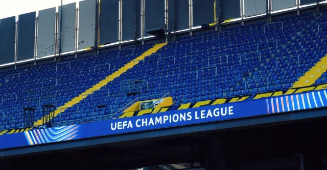 Empty stadium seats with UEFA Champions League banner visible, creating a sense of anticipation.